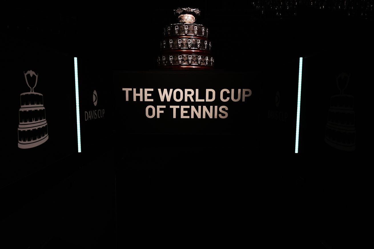 The World Cup of Tennis stands on a table, poorly lit and the viewer is only just able to make it out