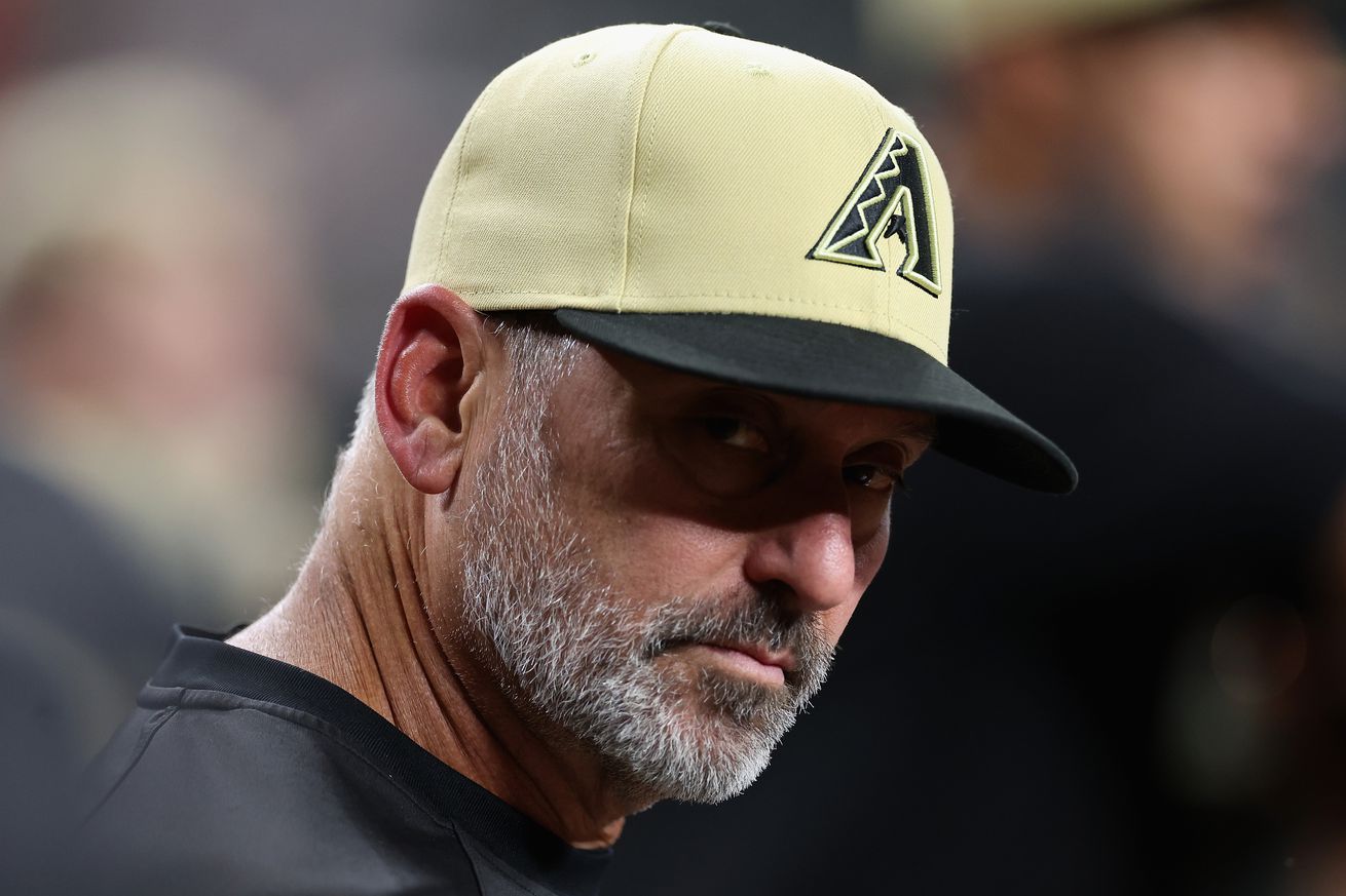 Torey Lovullo stars into the camera with the brim of his hat leaving his eyes in shadow