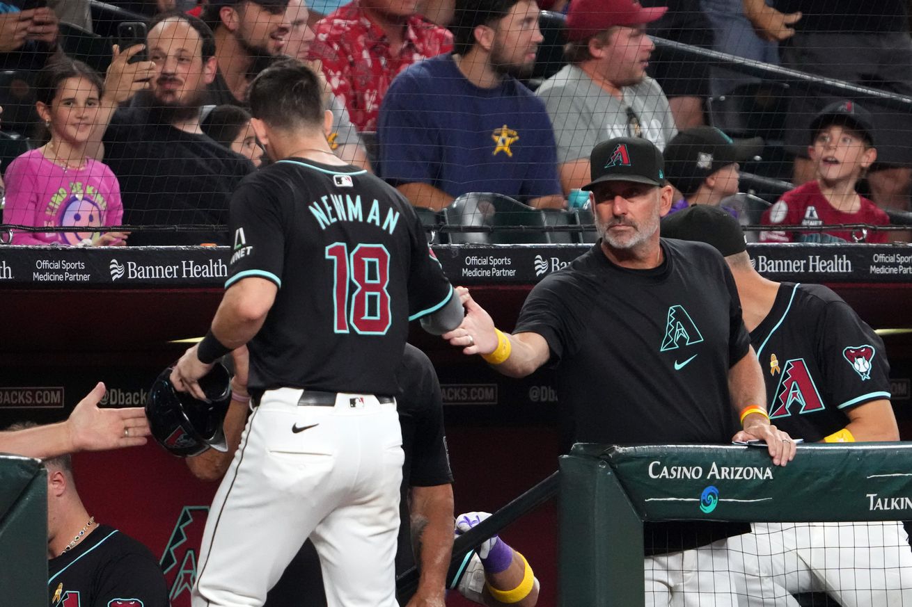 Torey Lovullo slaps hands with Kevin Newman.