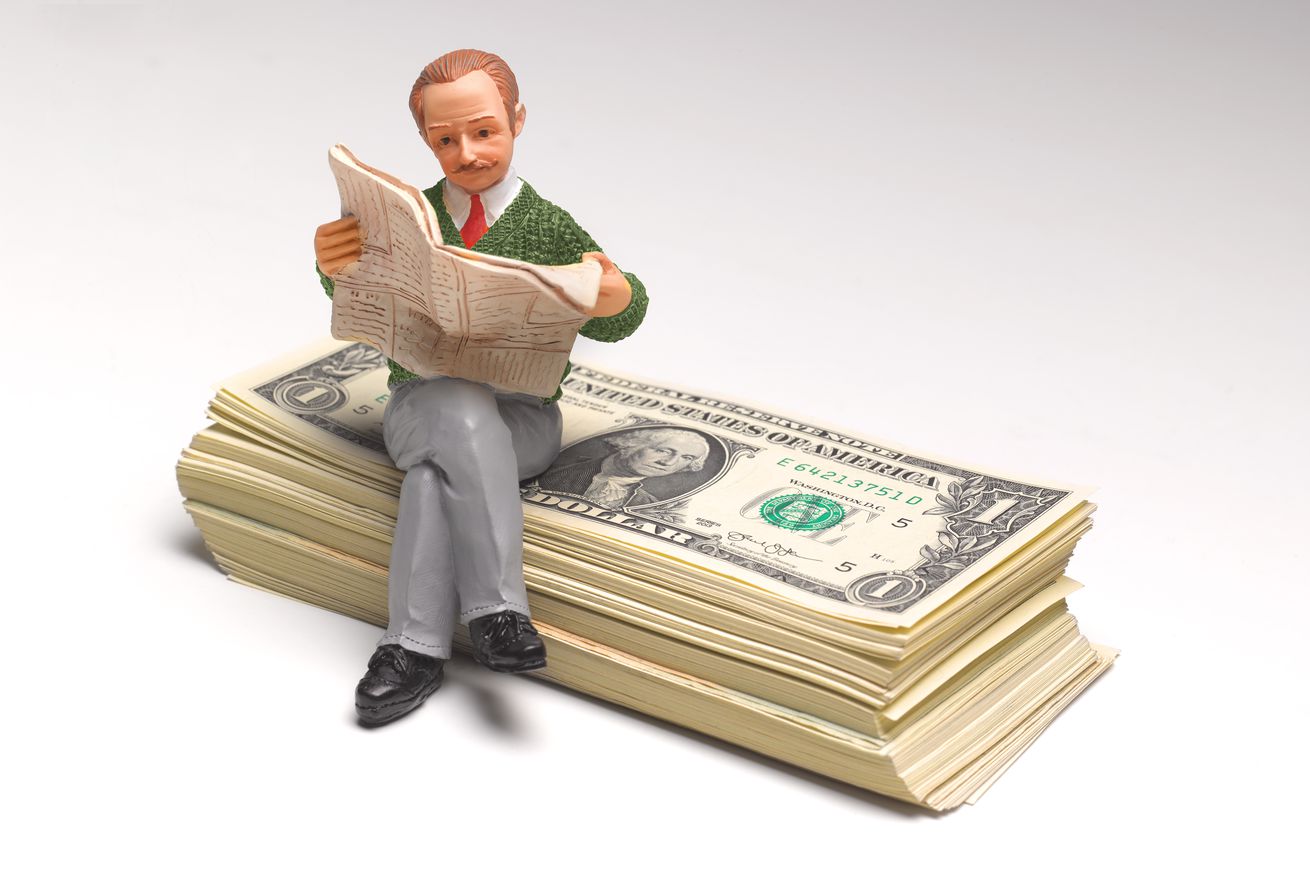 Pensioner sitting on stack of US Dollars