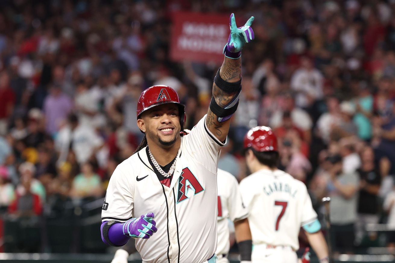 Ketel Marte celebrates hitting a home run with his hand held up with the middle two fingers down and the thumb, index, and pinky fingers held out