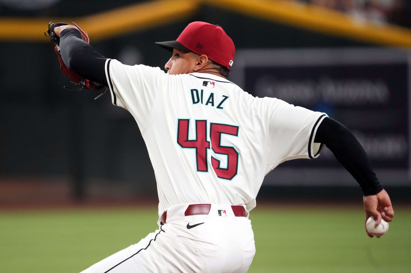 Yilber Diaz, wearing #45 Diamondbacks home white jersey, delivers a pitch against the Blue Jays at Chase Field