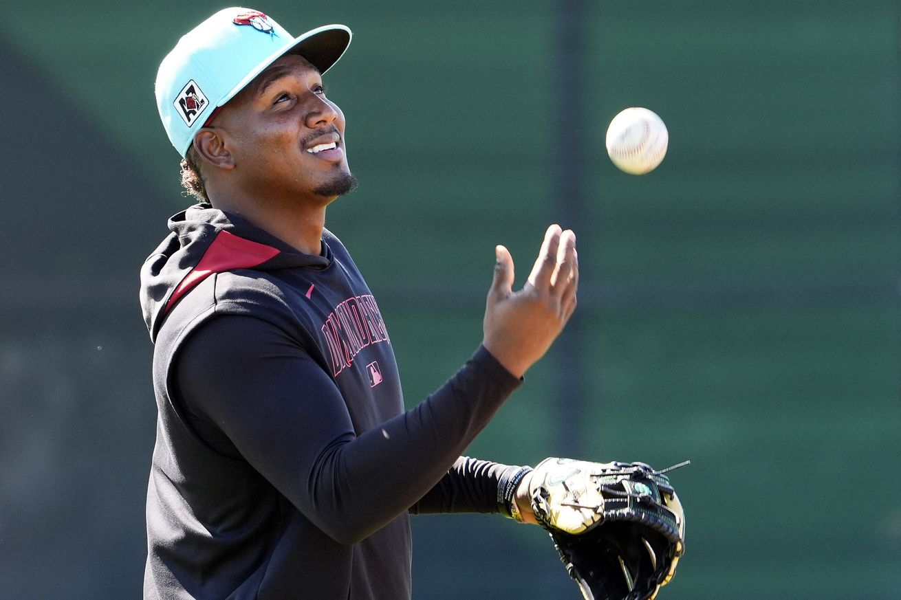 Perdomo tosses a baseball wearing Spring Training work out gear