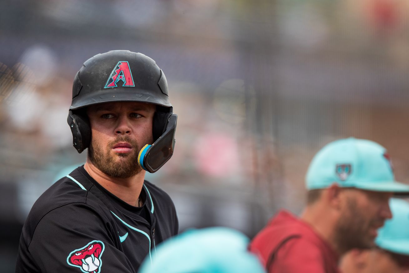 Tim Tawa stands up in the dugout.